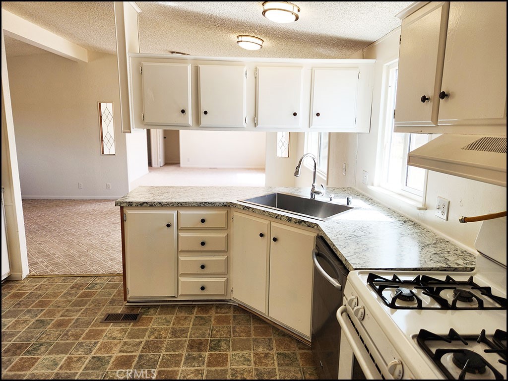 12232 Sheep Creek Road Phelan, CA 92371 - Photo 26 of 45 a kitchen with stainless steel appliances a sink stove and cabinets