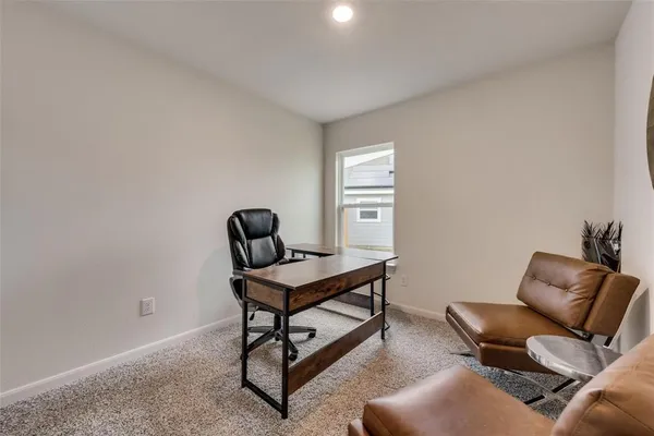 a view of a workspace with furniture and a window