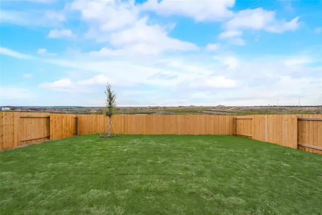 a view of a backyard with swimming pool and wooden fence