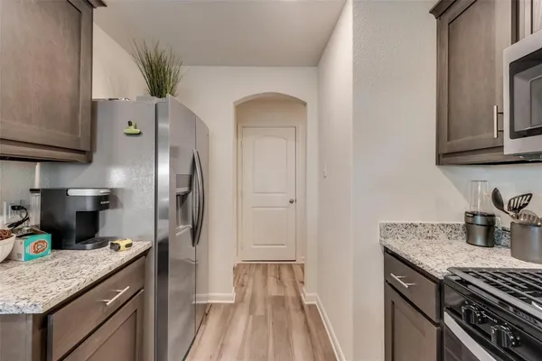 a kitchen with granite countertop a sink and refrigerator