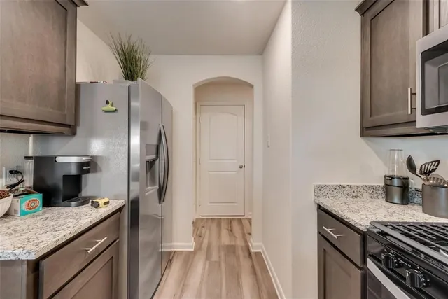 a kitchen with granite countertop a sink and refrigerator