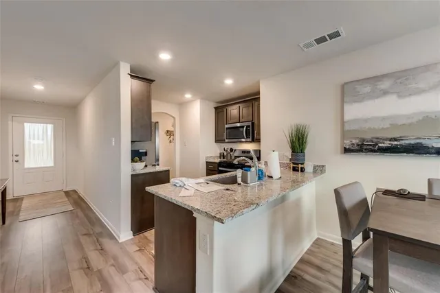 a kitchen with kitchen island granite countertop a sink cabinets and refrigerator