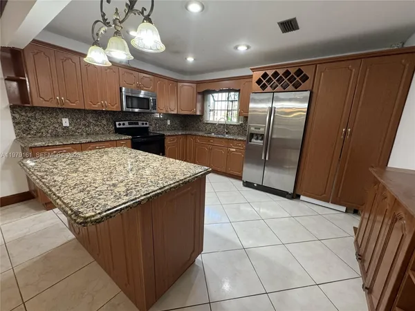 a kitchen with stainless steel appliances granite countertop a refrigerator and a sink