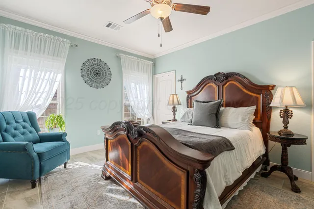 a spacious bedroom with a bed and a chandelier