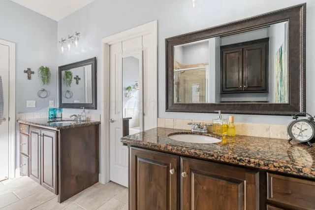 a bathroom with a granite countertop sink and a mirror