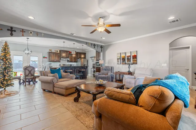 a living room with furniture kitchen view and a large window