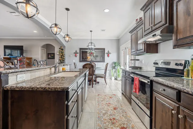 a kitchen with stainless steel appliances granite countertop a sink stove and refrigerator