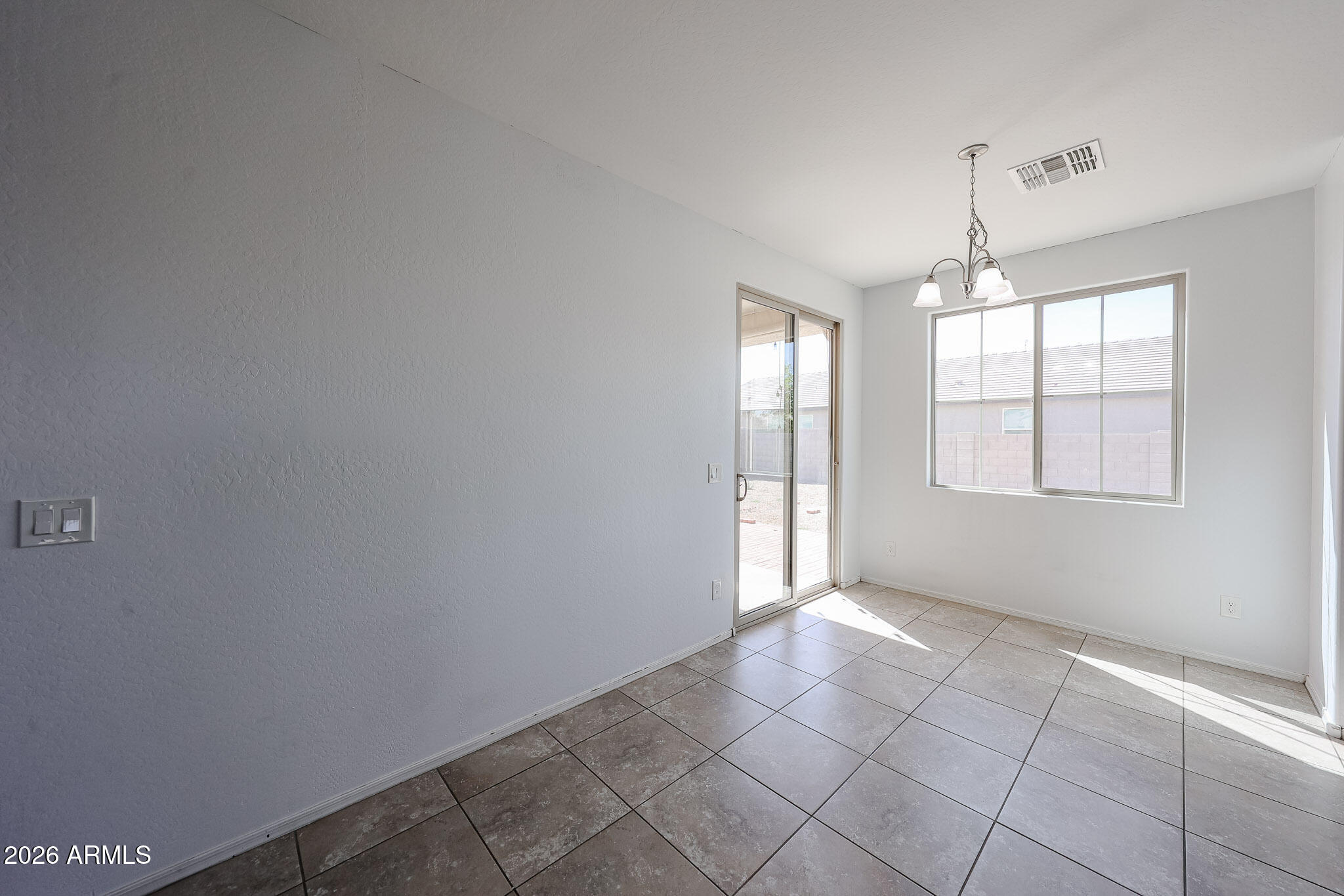 11967 West Rio Vista Lane Avondale, AZ 85323 - Photo 11 of 28 an empty room with windows and chandelier fan