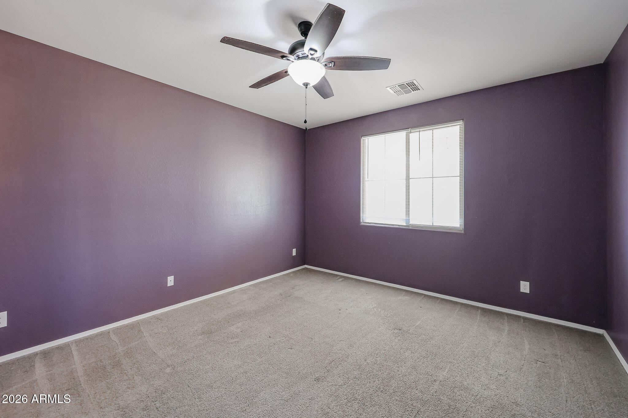 11967 West Rio Vista Lane Avondale, AZ 85323 - Photo 12 of 28 an empty room with a chandelier fan and windows