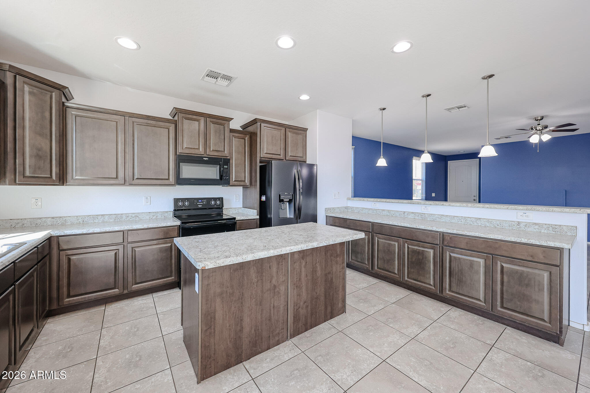 11967 West Rio Vista Lane Avondale, AZ 85323 - Photo 5 of 28 a kitchen with stainless steel appliances granite countertop a stove top oven a sink dishwasher and a refrigerator