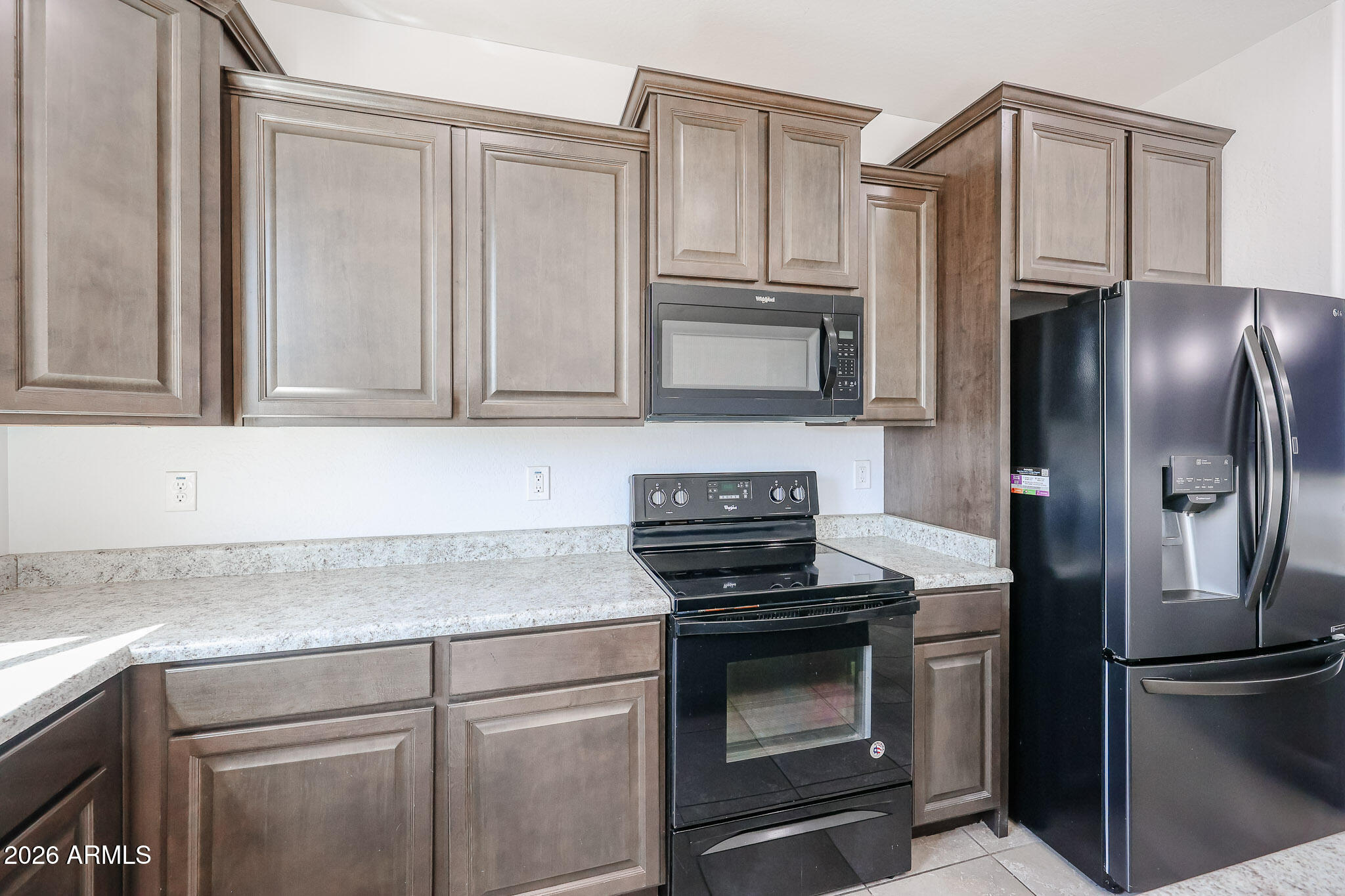 11967 West Rio Vista Lane Avondale, AZ 85323 - Photo 8 of 28 a kitchen with stainless steel appliances wooden cabinets and a stove top oven