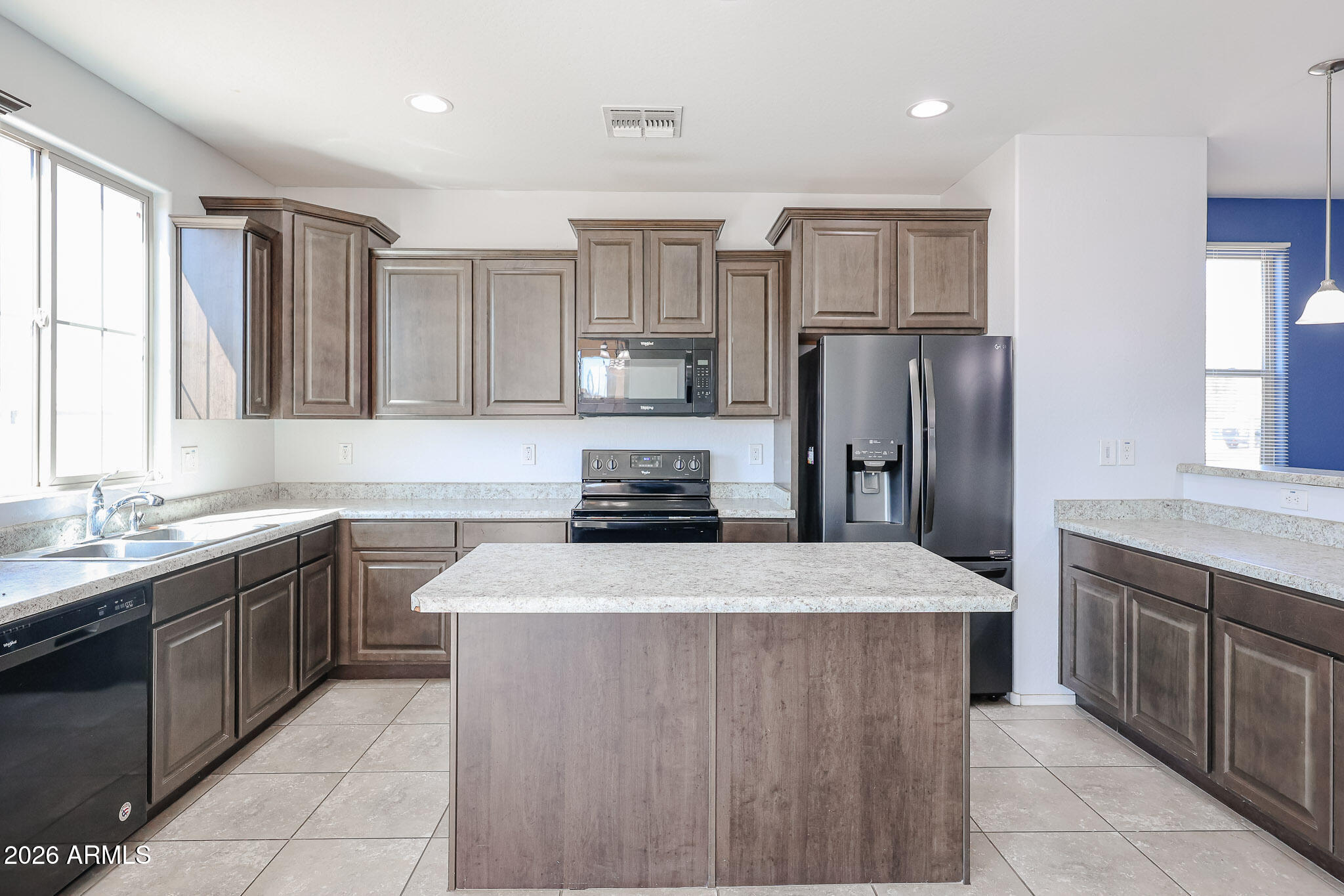 11967 West Rio Vista Lane Avondale, AZ 85323 - Photo 9 of 28 a kitchen with stainless steel appliances granite countertop a sink stove and refrigerator