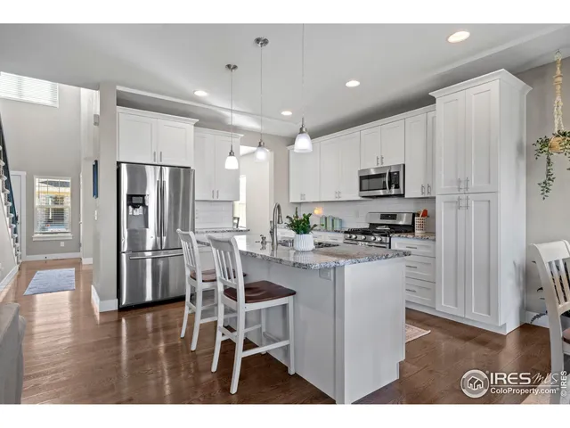 a kitchen with kitchen island white cabinets and stainless steel appliances