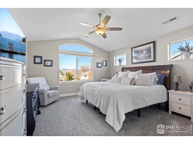 a spacious bedroom with a bed and a chandelier