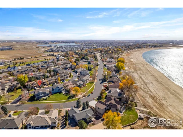 an aerial view of ocean and residential houses with outdoor space