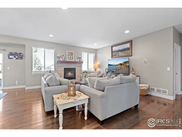 a living room with furniture a fireplace and a wooden floor