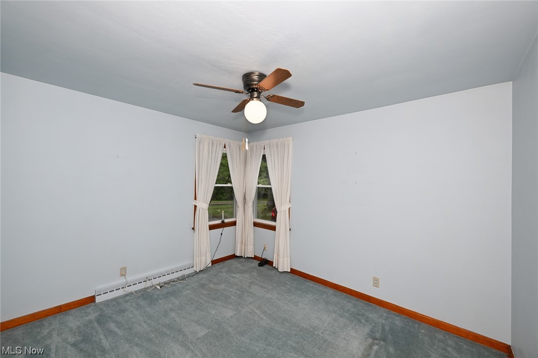 849 Bears Den Road Youngstown, OH 44511 - Photo 11 of 28 Carpeted empty room featuring a baseboard radiator and ceiling fan