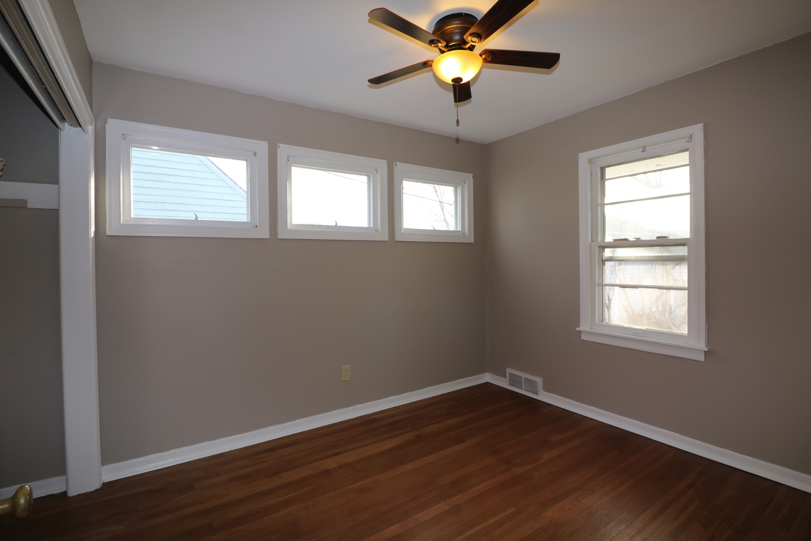 1307 South Jasper Street Decatur, IL 62521 - Photo 5 of 16 an empty room with wooden floor fan and windows