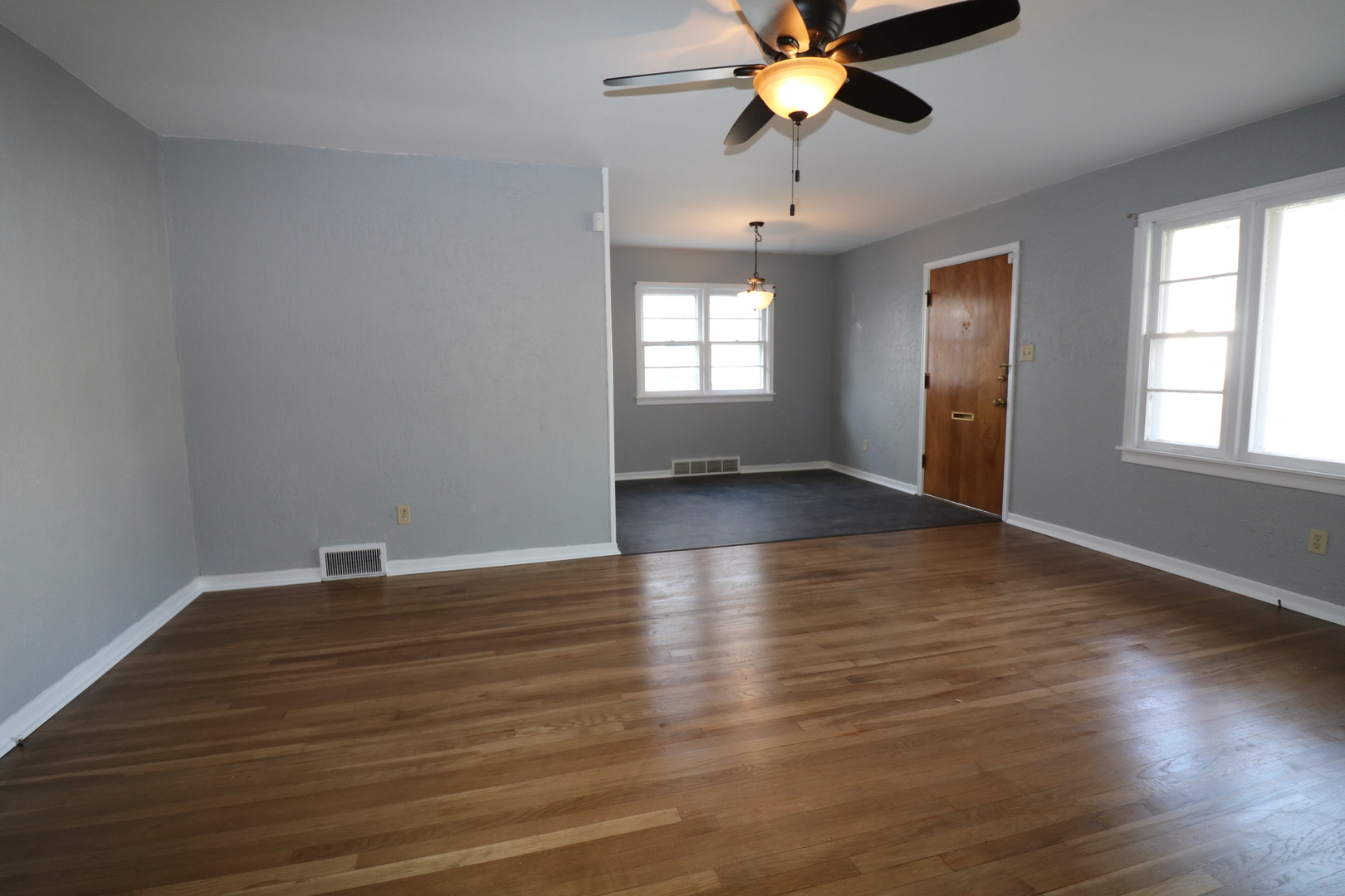 1307 South Jasper Street Decatur, IL 62521 - Photo 7 of 16 an empty room with wooden floor chandelier fan and windows