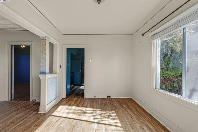 a view of a room with wooden floor and window