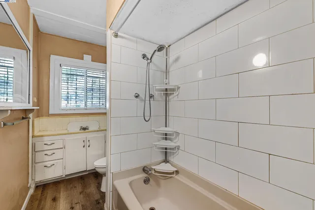 a bathroom with a granite countertop sink a toilet and a window