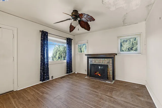 a view of an empty room with window and fireplace