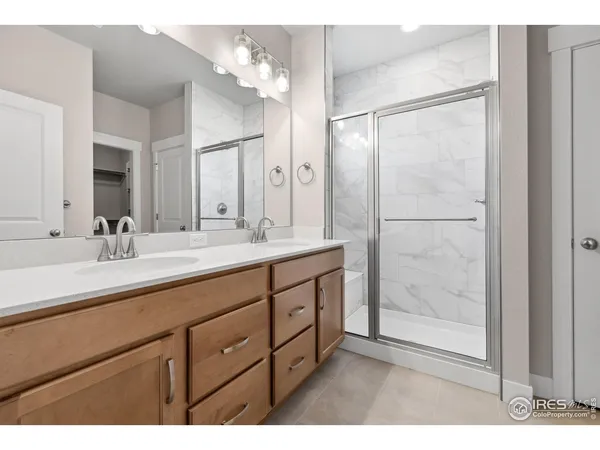 a bathroom with a double vanity sink mirror and shower