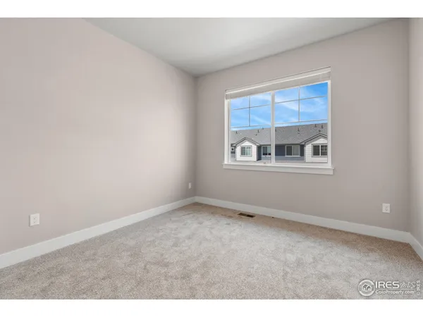 an empty room with windows and cabinet