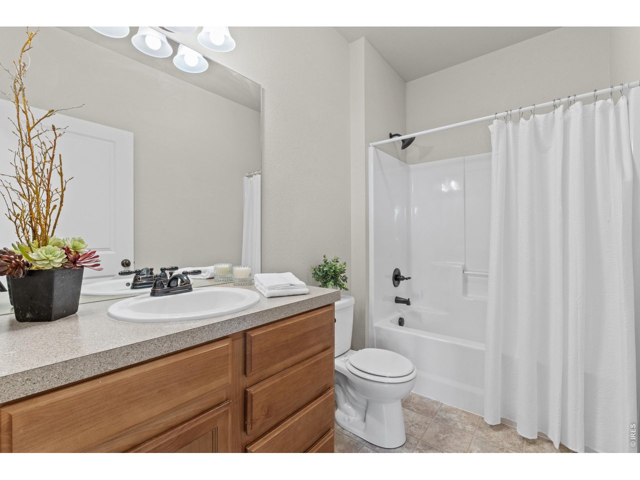 6911 West 3rd Street, Unit 810 Greeley, CO 80634 - Photo 17 of 28 a bathroom with a toilet a sink and a mirror