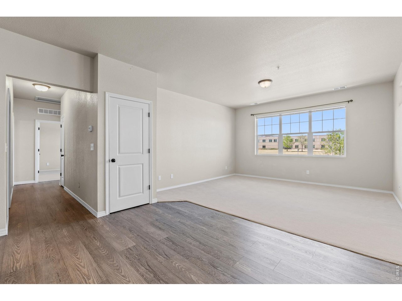 6911 West 3rd Street, Unit 810 Greeley, CO 80634 - Photo 7 of 28 a view of an empty room with a window and wooden floor