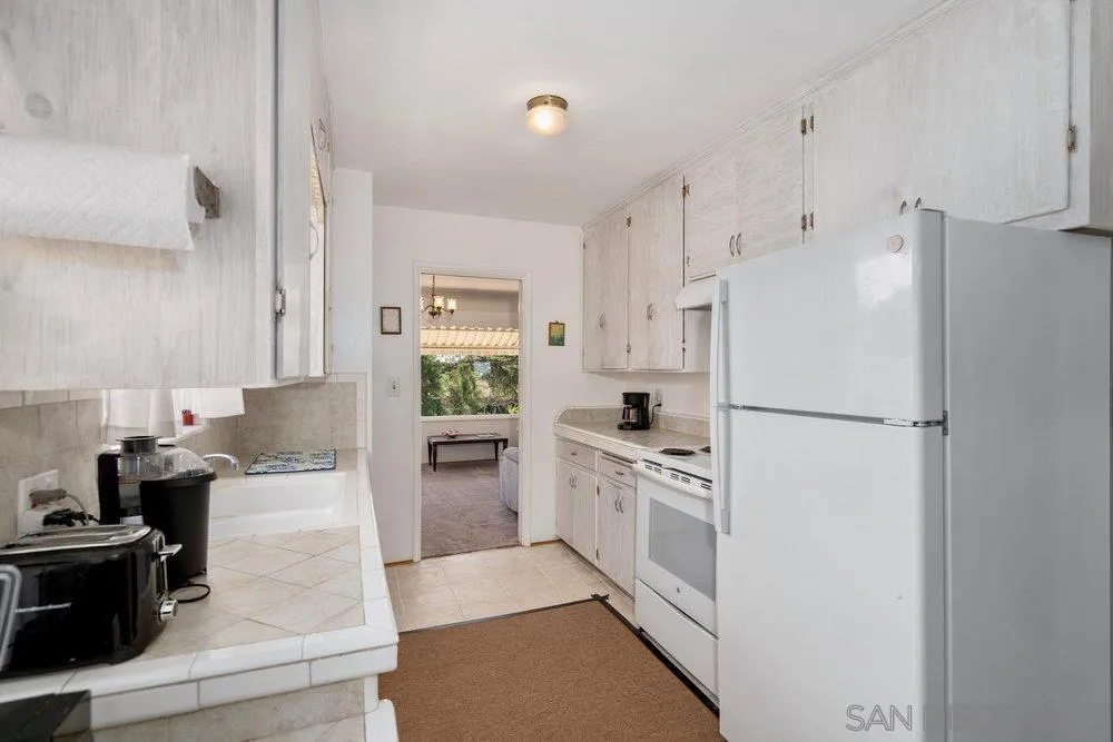 6109 Waverly Avenue La Jolla, CA 92037 - Photo 12 of 23 a kitchen with white cabinets and white appliances
