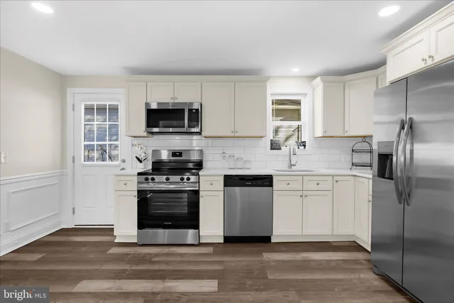 a kitchen with a refrigerator stove top oven and sink