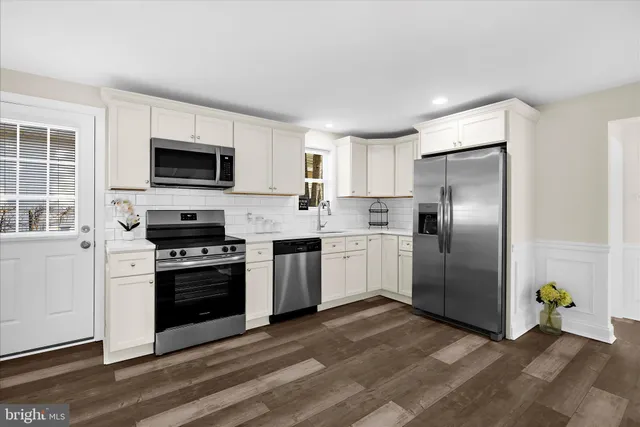 a kitchen with a refrigerator sink and cabinets