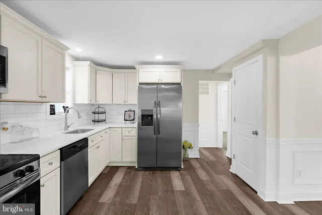 a kitchen with white cabinets and appliances