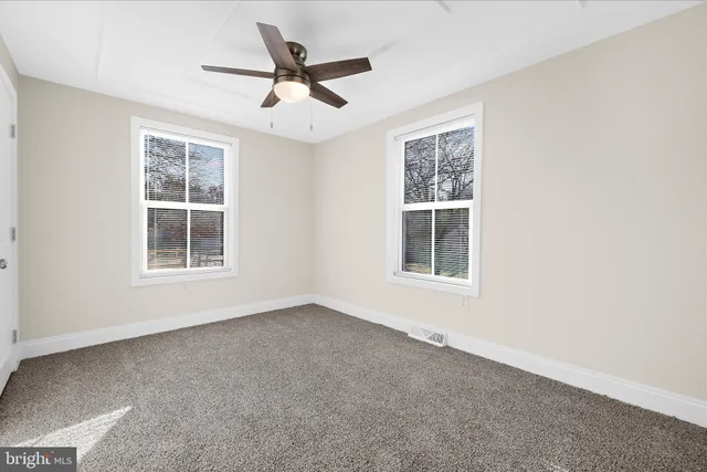 an empty room with chandelier fan