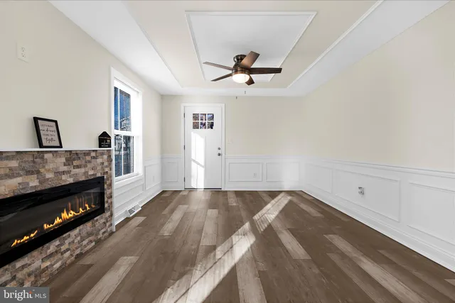 a view of empty room with wooden floor and fireplace