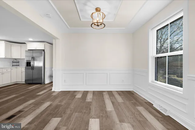 a view of empty room with wooden floor and window