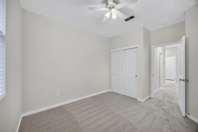 an empty room with a window and a fan