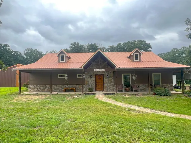 a front view of house with yard outdoor seating and barbeque oven