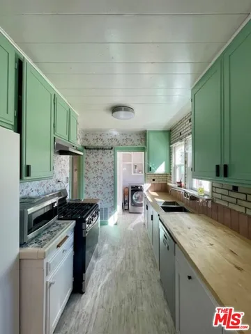 a kitchen with stainless steel appliances granite countertop a sink stove and cabinets