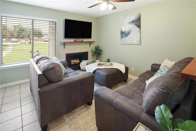 a living room with furniture a flat screen tv and a fireplace