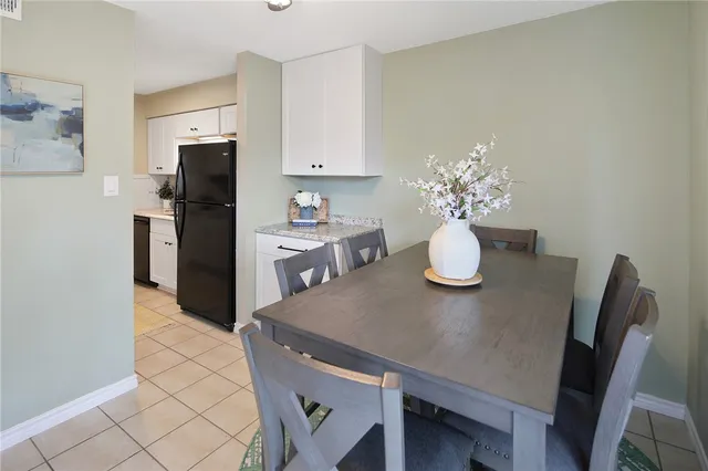 a kitchen with stainless steel appliances granite countertop a dining table chairs and a refrigerator
