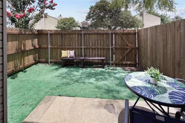 a backyard of a house with table and chairs