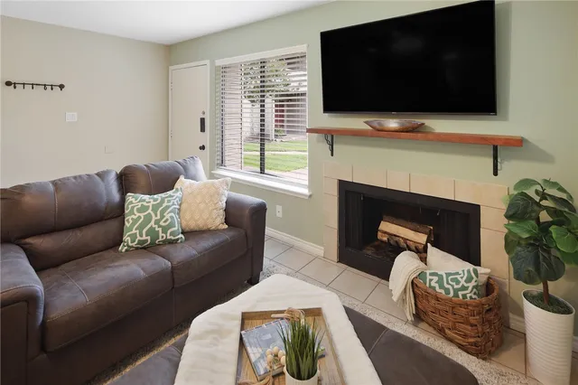 a living room with furniture a flat screen tv and a fireplace