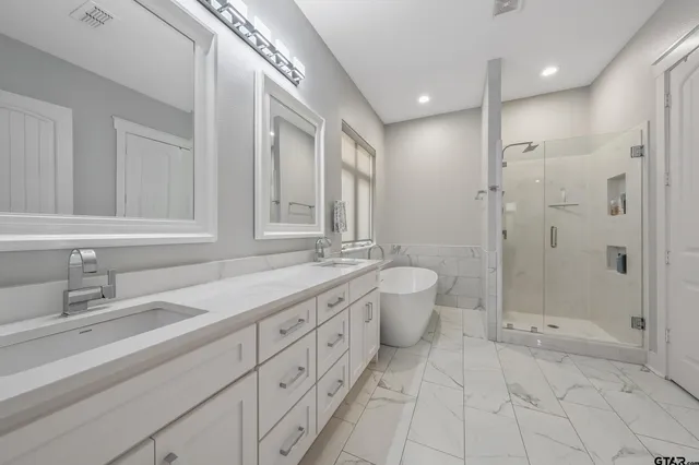 a bathroom with a granite countertop sink a toilet a mirror and shower