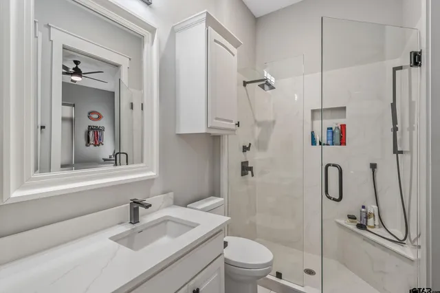 a bathroom with a sink a toilet and shower