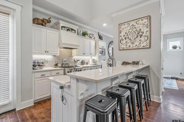 a kitchen with kitchen island a stove a table and chairs in it