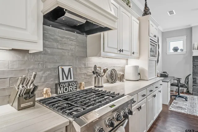 a kitchen with white cabinets and appliances