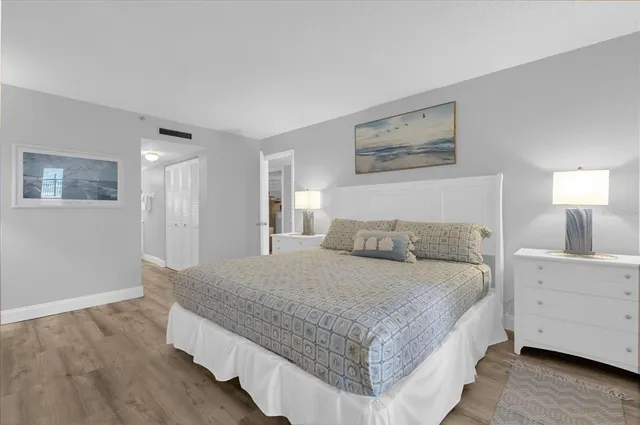 a bedroom with a bed a mirror and lamp