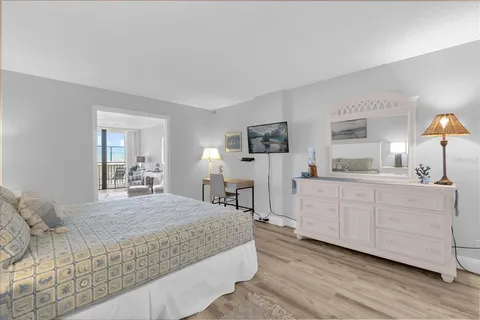 a bedroom with a bed a mirror and window